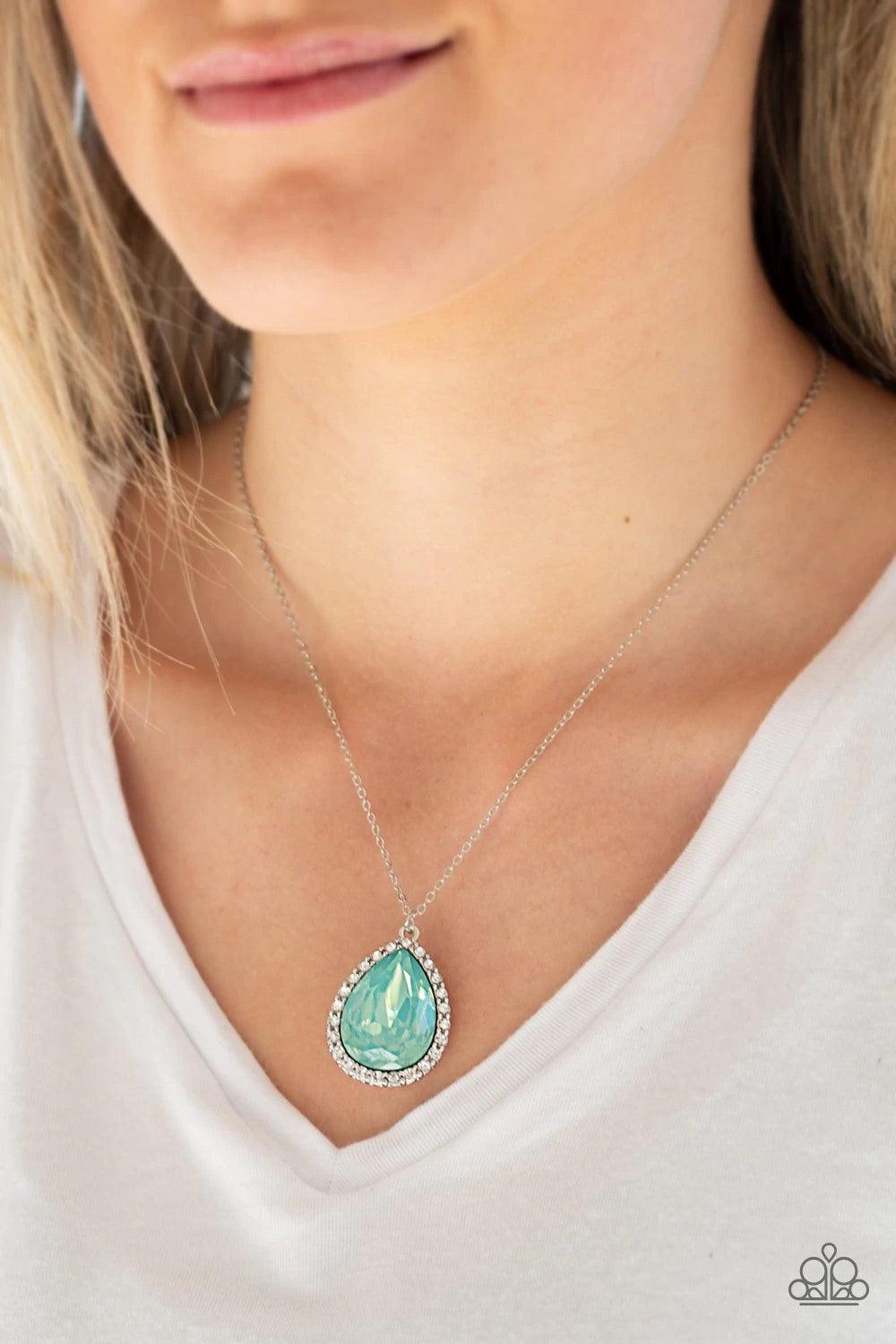 Paparazzi Accessories Come of AGELESS - Green Featuring an iridescent finish, a dramatic green teardrop gem is pressed into a shimmery silver frame radiating with glassy white rhinestones. The glamorous pendant swings from the bottom of a dainty silver ch