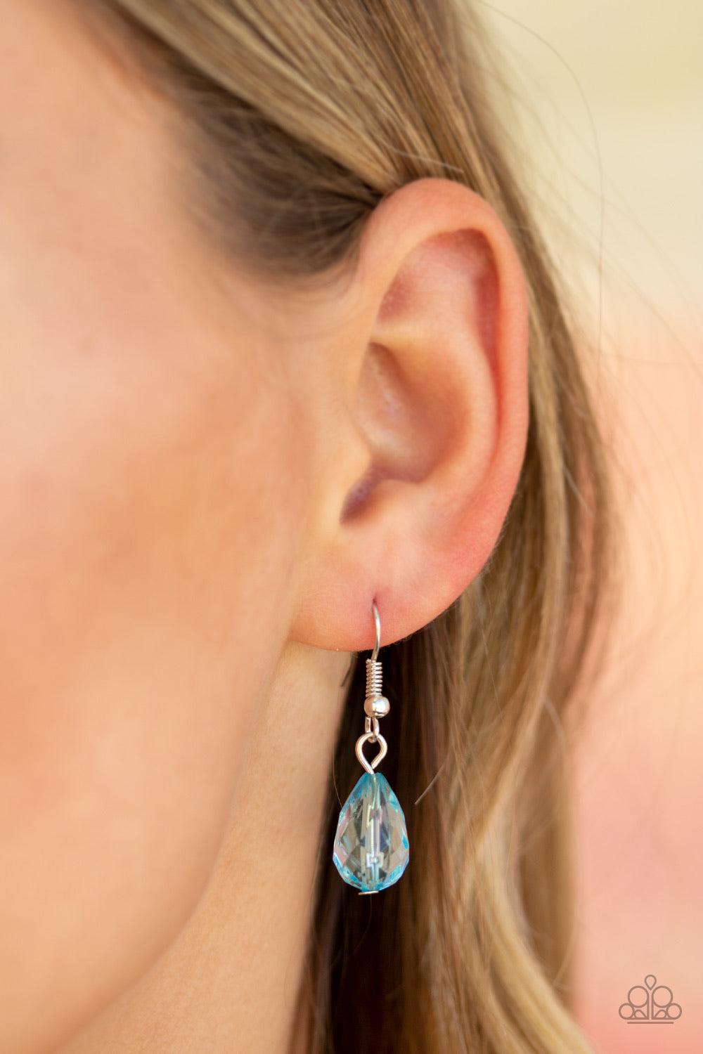 Paparazzi Accessories Beach Buzz - Blue Infused with an array of blue beads, a collection of antiqued silver shell and butterfly charms trickle along the bottom of a shimmery silver chain. Complemented with glittery white rhinestone encrusted beads, a dra