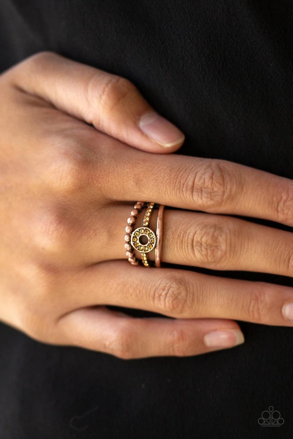 Paparazzi Accessories Cost of Living - Copper A smooth and dotted copper band flank a topaz rhinestone encrusted band, creating glittery layers across the finger. Encrusted in golden topaz rhinestones, a circular frame is pressed into the center of the ba