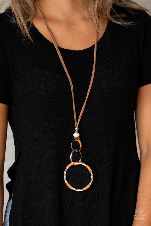 Paparazzi Accessories Rural Renovation - Orange Wrapped in sections of orange threaded accents, a mismatched trio of hammered silver rings link at the bottom of a beaded fitting. The earthy compilation is attached to lengthened strands of brown suede for