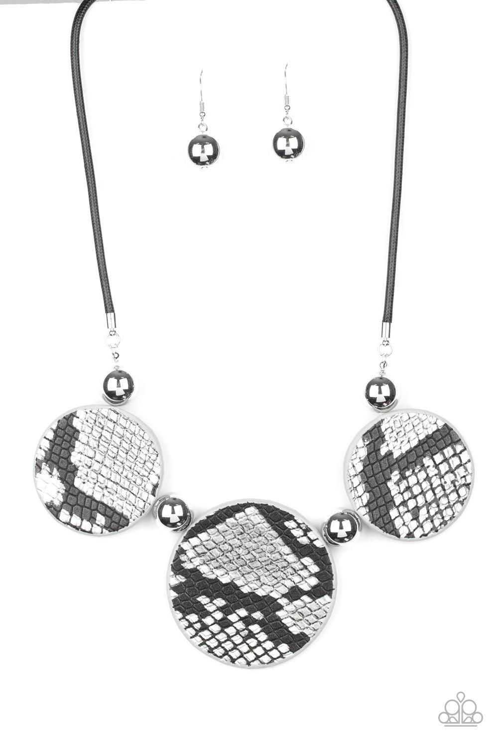 Paparazzi Accessories Viper Pit ~Black A wild collection of oversized silver beads and black and silver python patterned leather pieces are strung along an invisible wire below the collar for a statement-making finish. Features an adjustable clasp closure
