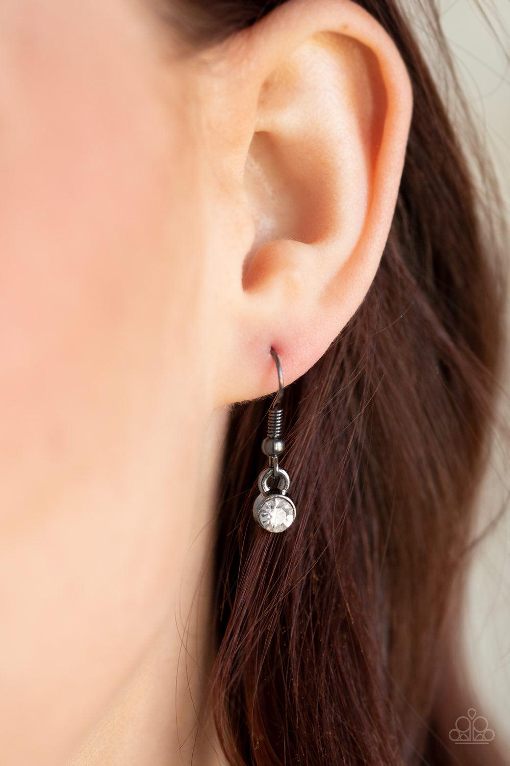 Paparazzi Accessories Not A HEIR Out Of Place - Black Encrusted in blinding white rhinestones, a sparkling gunmetal ring swings from the bottom of a lengthened gunmetal box chain. Flattened gunmetal chains stream from the bottom of the glittery pendant fo