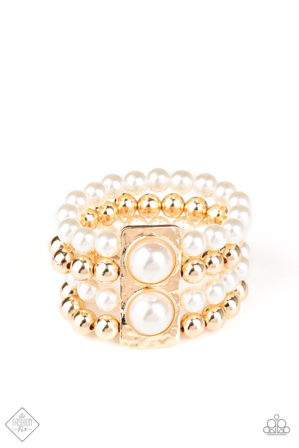 Paparazzi Accessories WEALTH-Conscious - Gold Held in place with a hammered gold frame dotted with two oversized white pearls, strands of classic gold beads and white pearls are threaded along stretchy bands that wrap around the wrist in a glamorously lay
