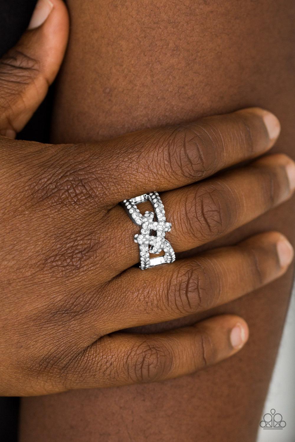 Paparazzi Accessories Can Only Go UPSCALE From Here - White Encrusted in white glittery rhinestones, shimmery silver bars crisscross across the finger, coalescing into a bold square knot atop the finger. Features a stretchy band for a flexible fit. Jewelr
