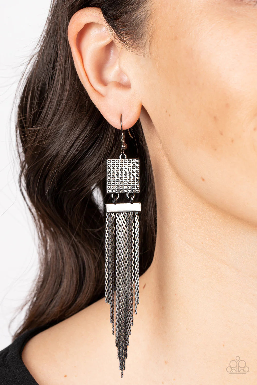 Paparazzi Accessories Dramatically Deco - Black A tapered curtain of flat gunmetal chains cascades from a gunmetal rectangular fitting that delicately links to a gunmetal square frame dotted in dainty hematite rhinestones, resulting in a trendy tassel. Ea