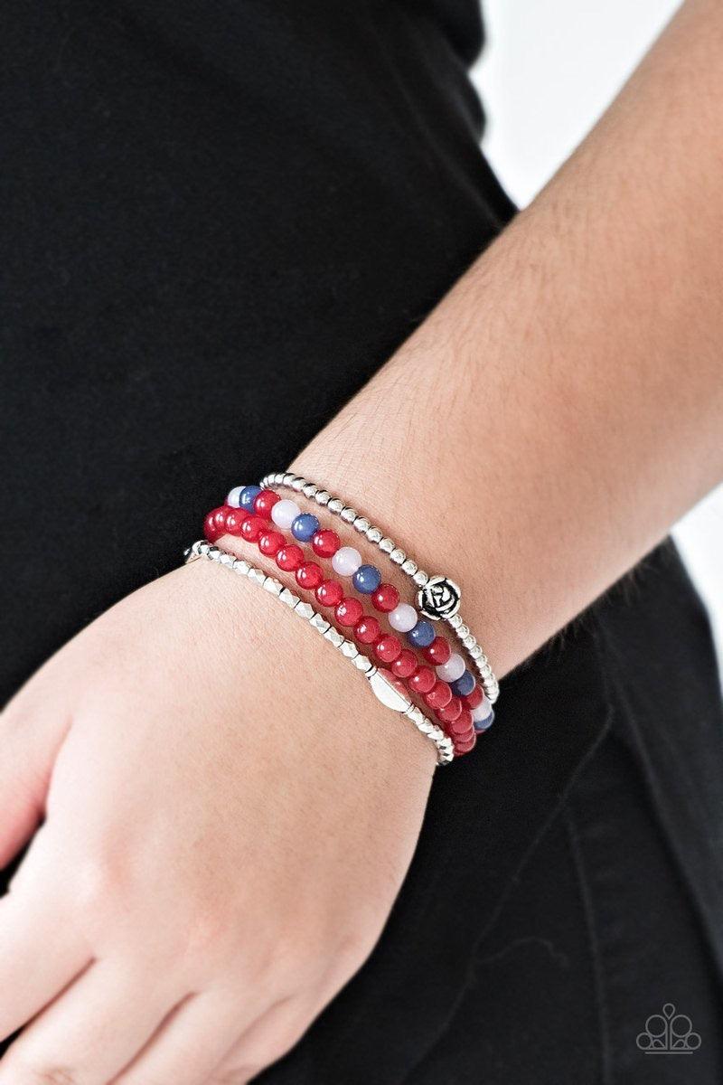 Paparazzi Accessories Blooming Buttercups - Red Mismatched silver beads and strands of glassy red beads are threaded along stretchy bands. Infused with silver accents, dainty rose blossoms adorn the wrist for a seasonal finish. Jewelry
