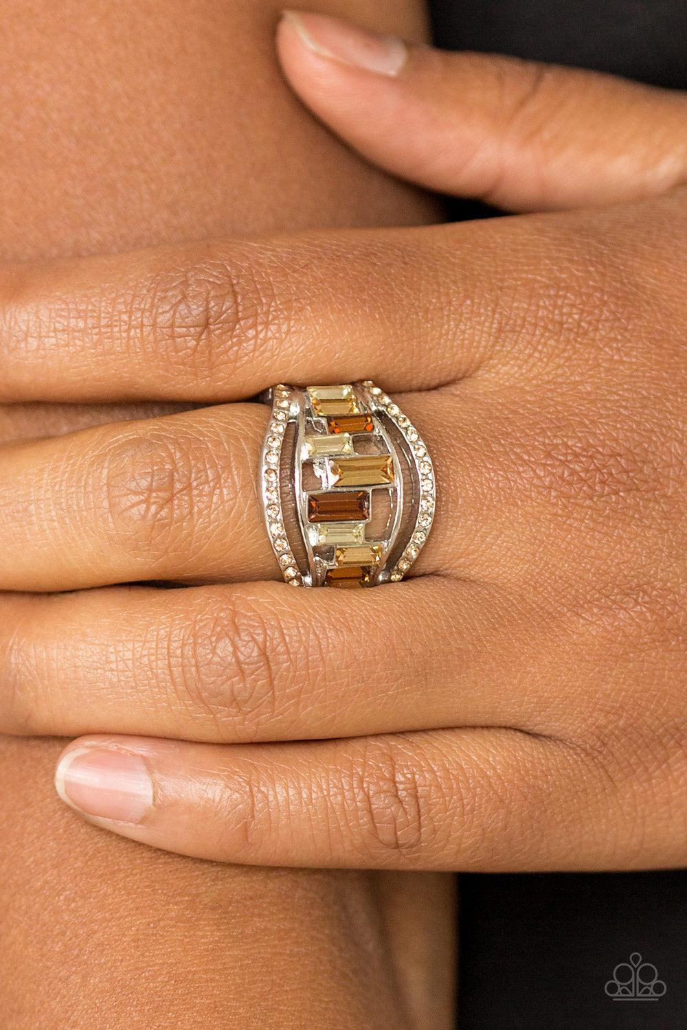Paparazzi Accessories Treasure Chest Charm - Brown Topaz rhinestone encrusted bands flank a row of emerald cut glass beads in shades of brown and white for a regal look. Features a stretchy band for a flexible fit. Jewelry