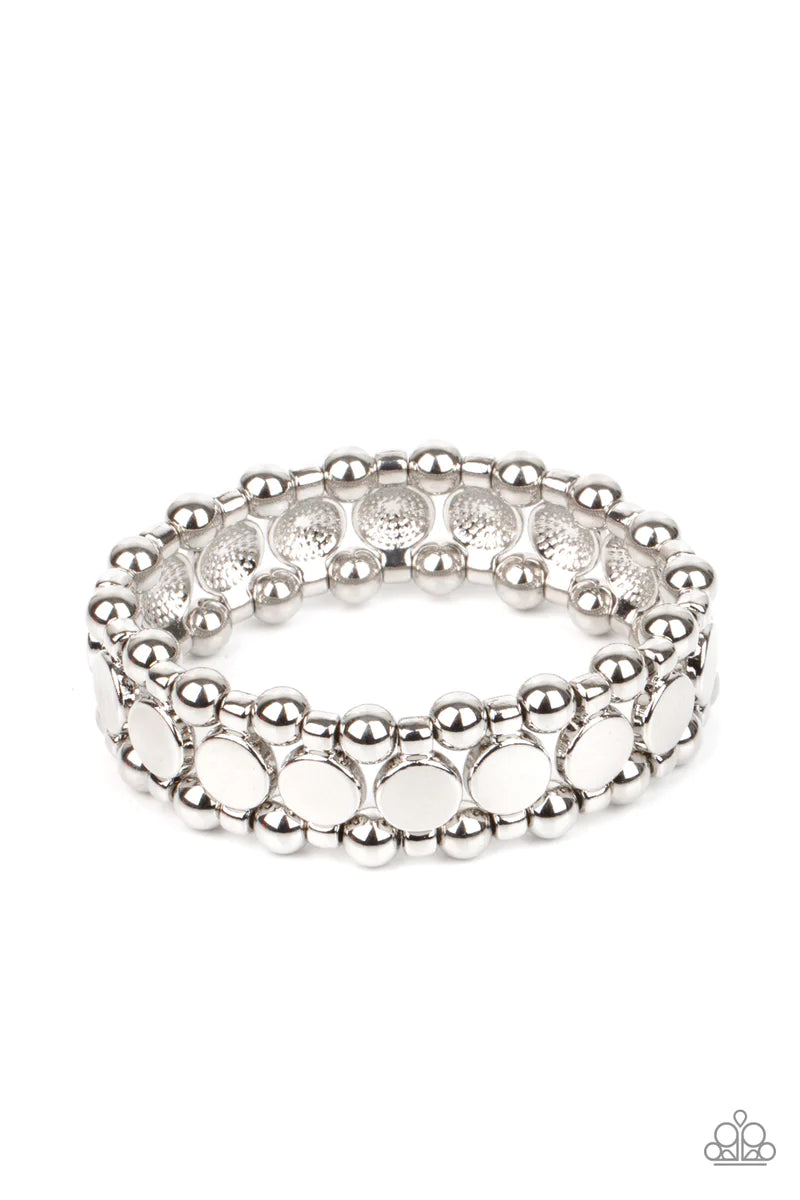 Paparazzi Accessories Metro Magnetism - Silver Shiny silver disc fittings and pairs of classic silver beads are threaded along stretchy bands around the wrist that connect into a bold industrial display around the wrist. Sold as one individual bracelet. B