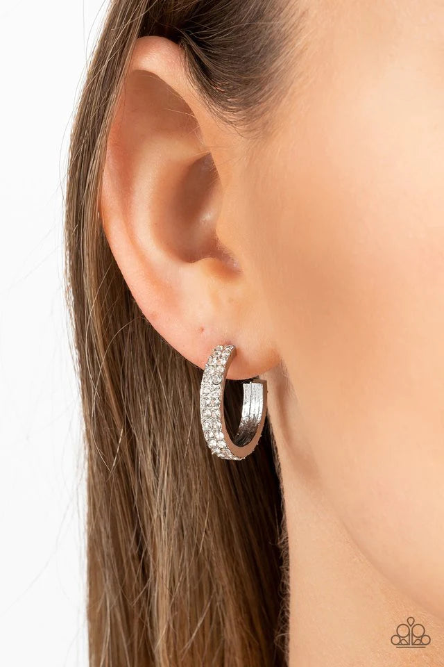 Paparazzi Accessories Positively Petite - White Sparkling white rhinestones line the front of a petite silver hoop, creating edge to edge shimmer. Earring attaches to a standard post fitting. Hoop measures approximately 3/4 in diameter. Sold as one pair o