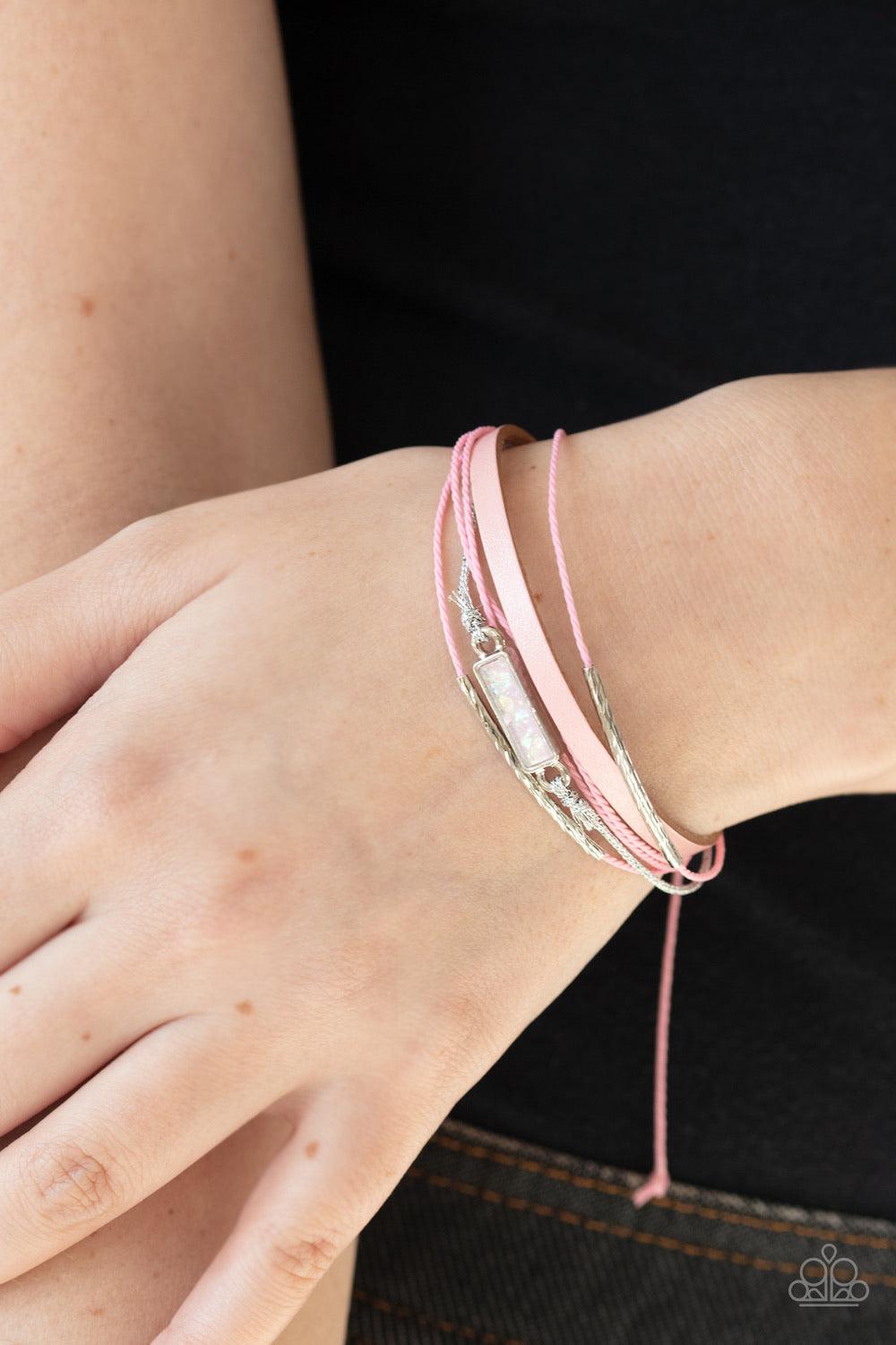 Paparazzi Accessories Interstellar Iridescence - Pink Featuring dainty silver barrel beads and a pink opalescent stone-like frame, a collection of pink leather, and pink and silver cording layers across the wrist for a colorful look. Features an adjustabl