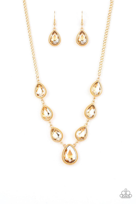 Paparazzi Accessories Socialite Social - Gold Featuring ornate gold frames, golden teardrop gems link below the collar in a timeless fashion. The largest teardrop swings from the center, creating a glamorous pendant. Features an adjustable clasp closure.