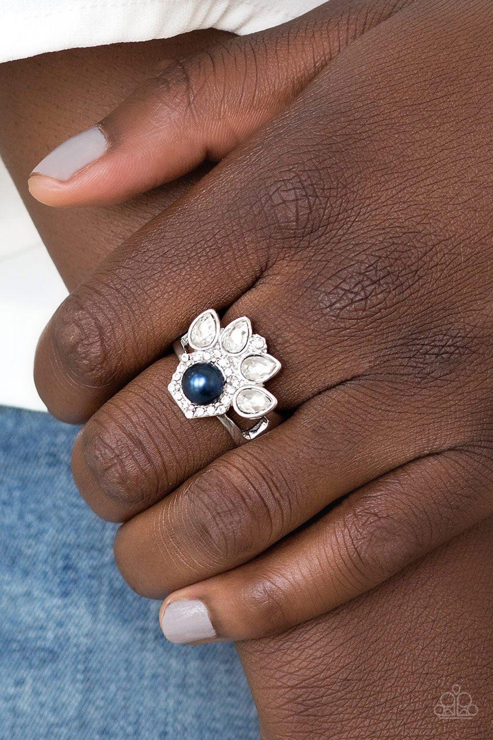 Paparazzi Accessories Crown Coronation - Blue Featuring regal teardrop cuts, glittery white rhinestones flare from the center of a blue pearl drop center. Dainty white rhinestones spin around the pearly center for a glamorous finish. Features a stretchy b
