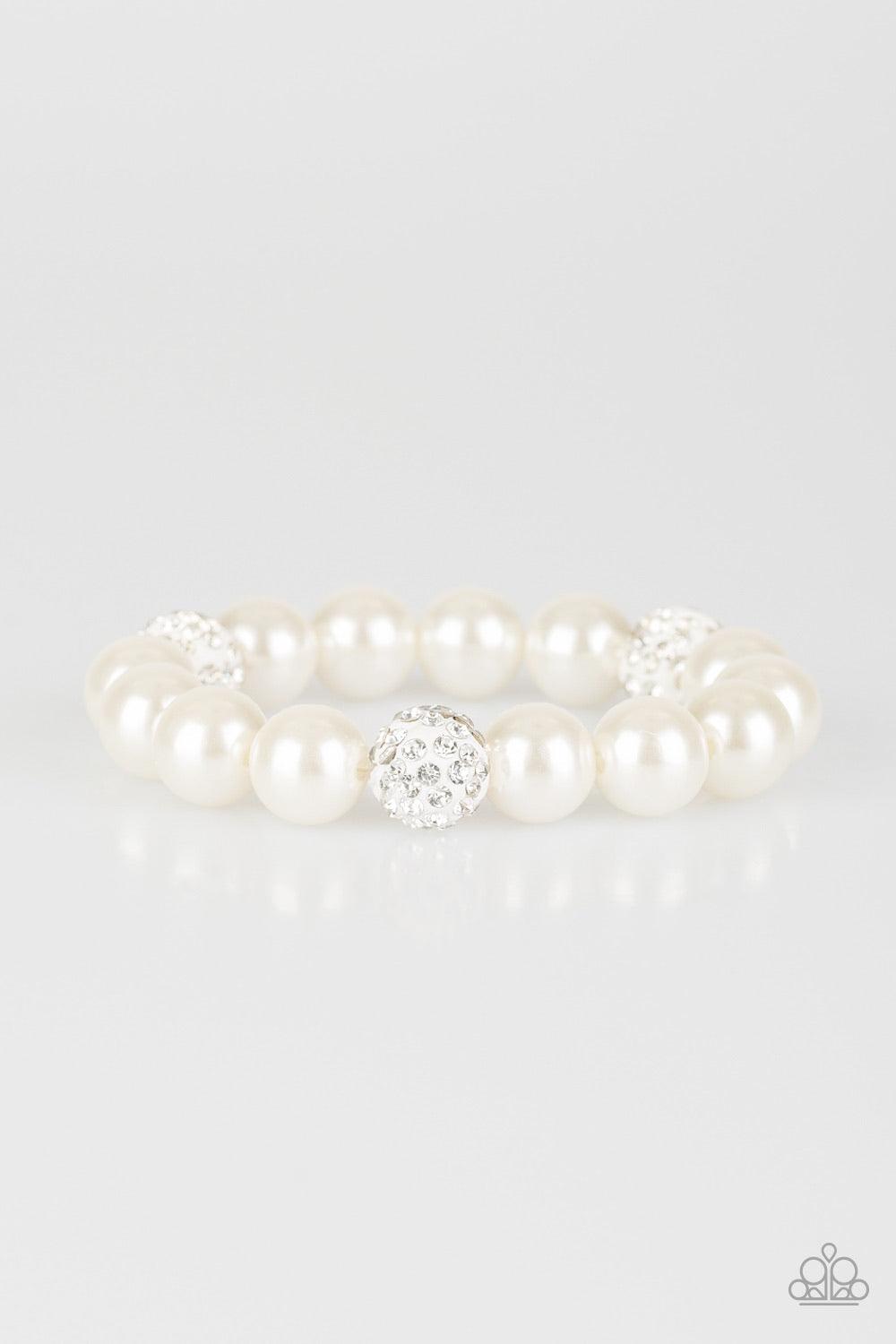 Paparazzi Accessories Cake Walk - White A collection of white pearls and white rhinestone encrusted beads are threaded along a stretchy band around the wrist for a refined flair. Sold as one individual bracelet. Jewelry