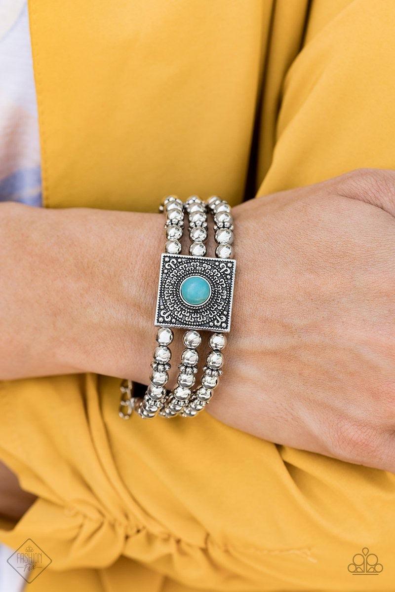 Paparazzi Accessories Solstice Soul - Blue Infused with ornate silver frames, strands of shiny silver beads and studded silver accents are threaded along invisible wires across the wrist. Dotted with a refreshing turquoise stone, a filigree-filled square