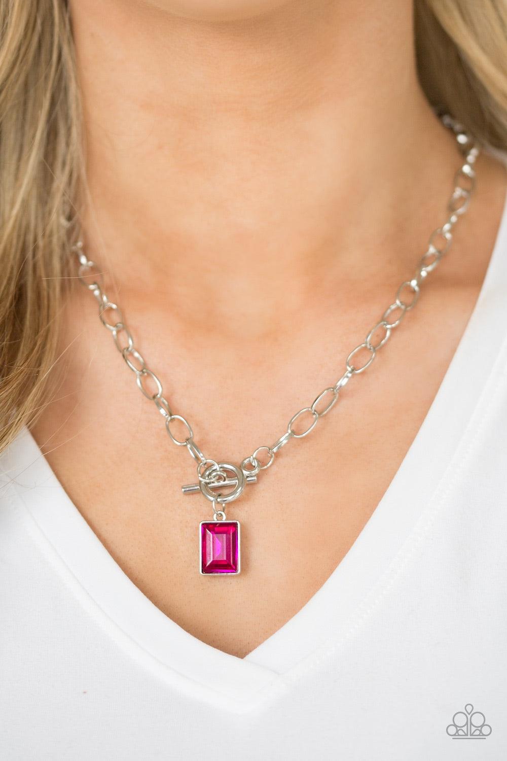 Paparazzi Accessories Wear It Like You Mean It! - Pink Featuring a regal emerald-style cut, a glassy pink rhinestone is pressed into a sleek silver frame. The glittery frame swings from the bottom of a bold silver chain, creating a glamorous pendant below