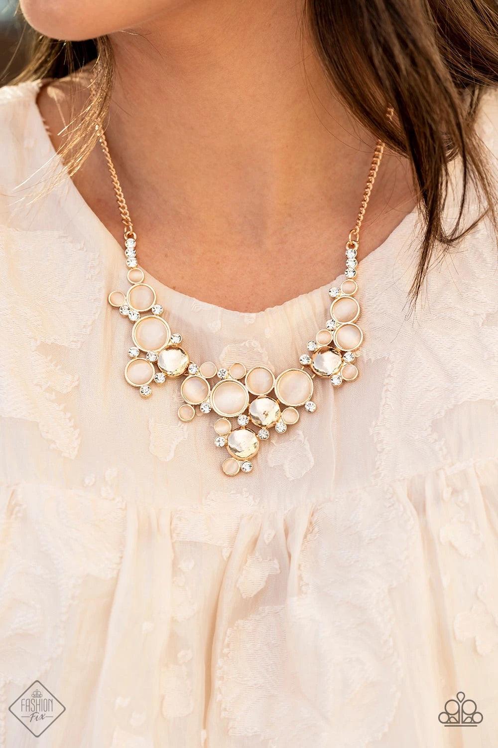 Paparazzi Accessories Fairytale Affair - Gold A bubbly collection of champagne cat's eye stones, glassy white rhinestones, and glistening gold discs delicately coalesces into enchanting frames below the collar that link into a whimsical centerpiece. Featu