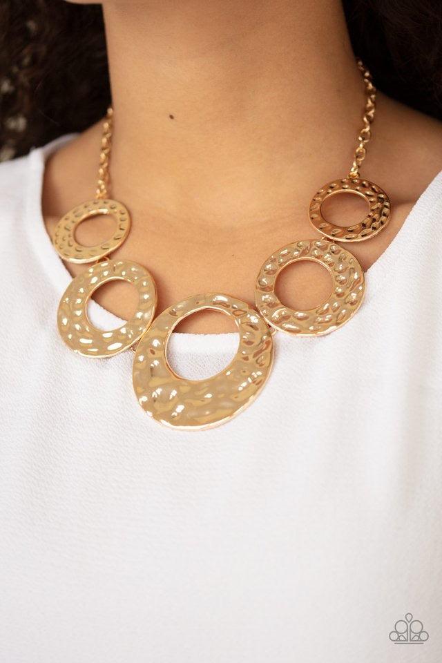 Paparazzi Accessories Mildly Metro - Gold Gradually increasing in size, hammered gold circles link below the collar for a statement-making look. Features an adjustable clasp closure. Jewelry