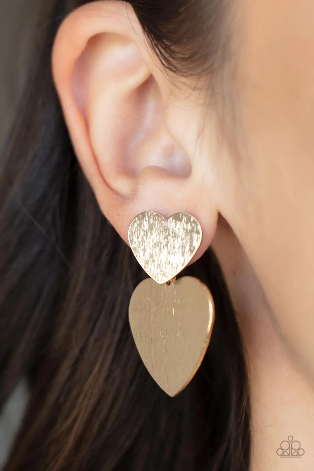 Paparazzi Accessories Heart-Racing Refinement - Gold Delicately scratched in shimmer, a dainty gold heart frame delicately links with a larger gold heart frame for a flirtatiously layered look. Earring attaches to a standard post earring. Sold as one pair