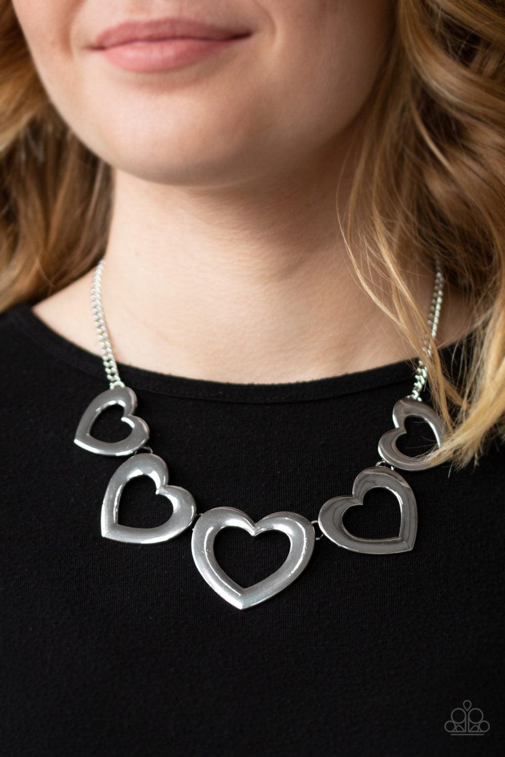 Paparazzi Accessories Hearty Hearts ~Silver Gradually increasing in size, glistening silver heart silhouettes delicately link below the collar in a charming fashion. Features an adjustable clasp closure.