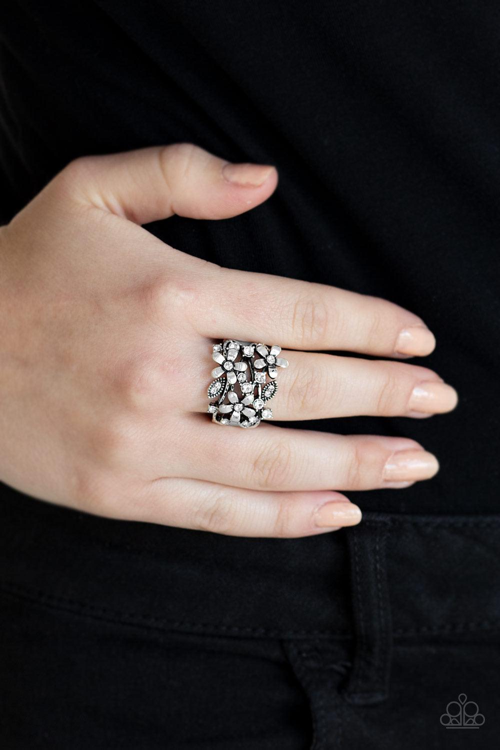 Paparazzi Accessories Gardenia Gleam ~White Dotted with glittery white rhinestones, a trio of shimmery silver flowers bloom across the finger, coalescing into a whimsical band. Features a stretchy band for a flexible fit.