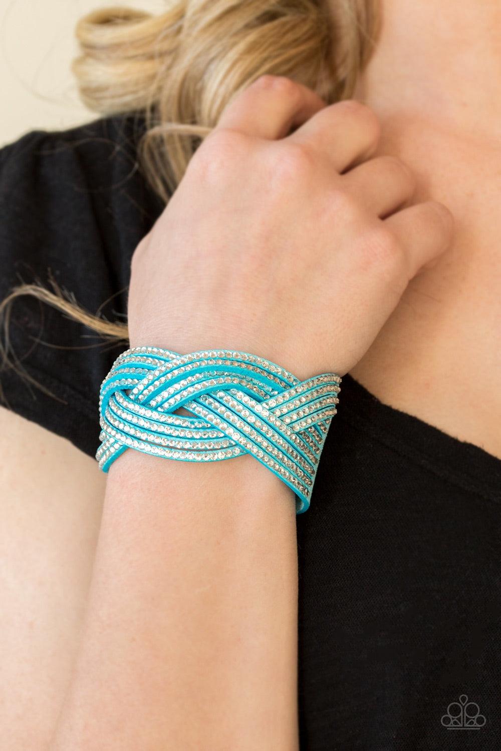Paparazzi Accessories Big City Shimmer - Blue Glassy white rhinestones are encrusted along crisscrossing strands of blue suede, creating bold shimmer around the wrist. Features an adjustable snap closure. Jewelry