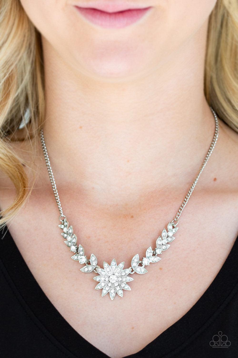 Paparazzi Accessories Garden Glamour - White Encrusted in glassy white rhinestones, glittery leafy frames give way to a blooming silver frame encrusted in dazzling white rhinestones below the collar for a sparkling seasonal finish. Features an adjustable
