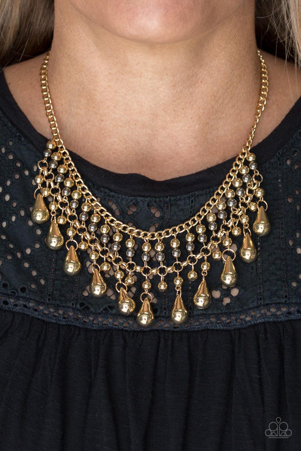 Paparazzi Accessories Don’t Forget To BOSS! - Gold Threaded along metallic rods, stacked gold and gunmetal beads give way to shimmery gold teardrops. The edgy fringe flawlessly drapes beneath the collar, creating a sassy tapered fringe. Features an adjust