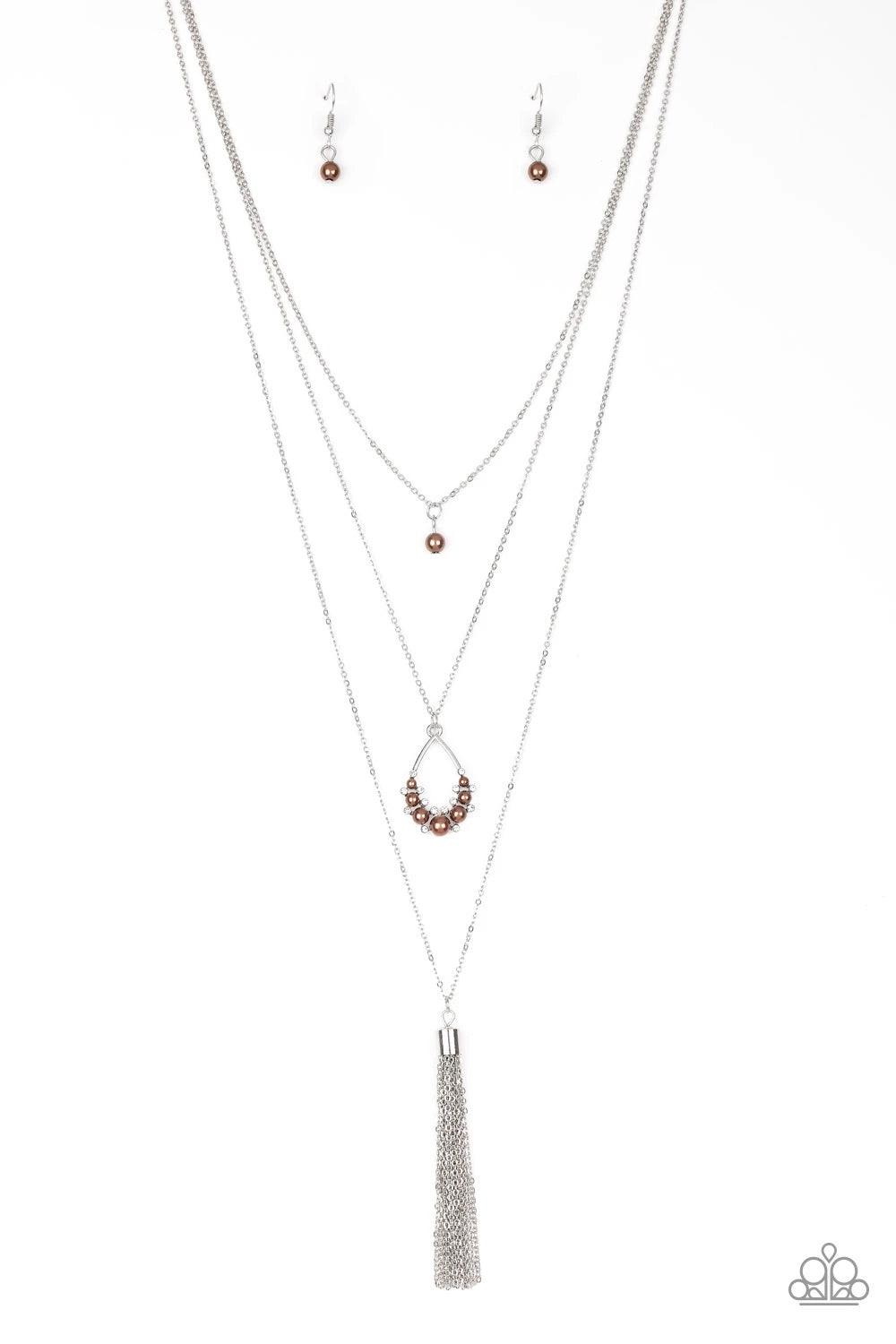 Paparazzi Accessories Be Fancy - Brown A solitaire brown pearl swings from the uppermost chain, giving way to a teardrop pendant and shimmery silver chain tassel. Dainty white rhinestones and brown pearls collect at the bottom of the centermost pendant fo