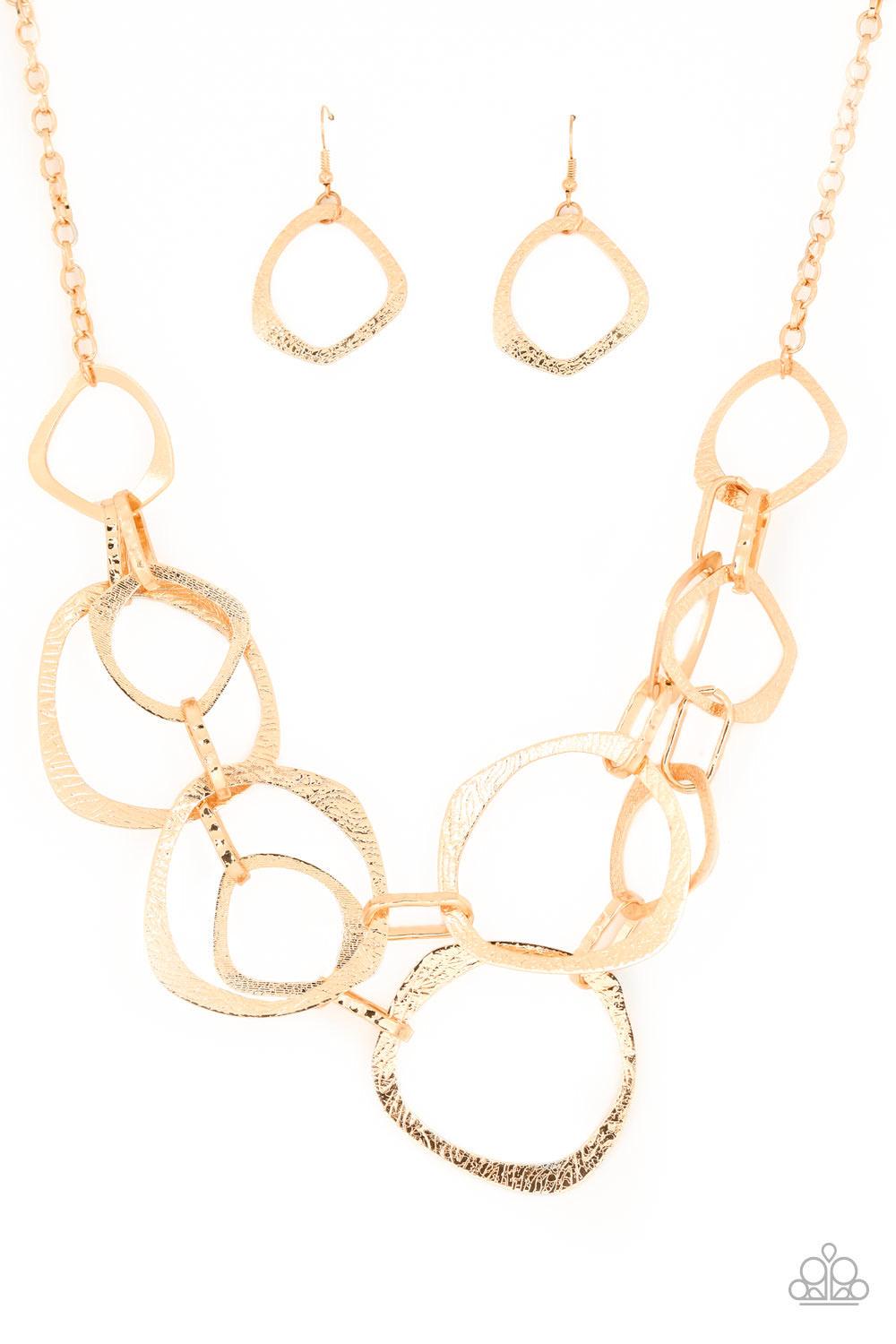Paparazzi Accessories Salvage Yard - Gold Hammered in shimmery detail, oversized asymmetrical gold rings and gritty gold links boldly link below the collar in two dramatic rows for a sassy industrial look. Features an adjustable clasp closure. Sold as one