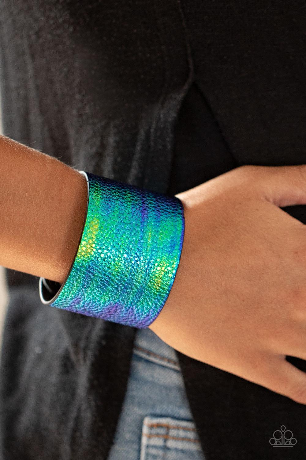 Paparazzi Accessories Cosmo Cruise - Blue Featuring an iridescent crocodile print, a shimmery blue and green tie-dye leather band wraps around the wrist for an out-of-this-world fashion. Features an adjustable snap closure. Sold as one individual bracelet