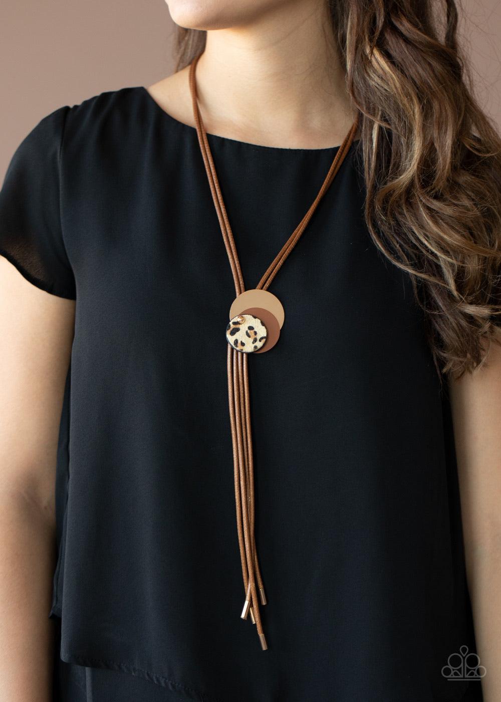 Paparazzi Accessories I’m FELINE Good - Brown .A trio of gold, brown, and fuzzy cheetah print discs overlap into an adjustable pendant along rows of shiny brown cording for a wildly retro look. Sold as one individual necklace. Includes one pair of matchin
