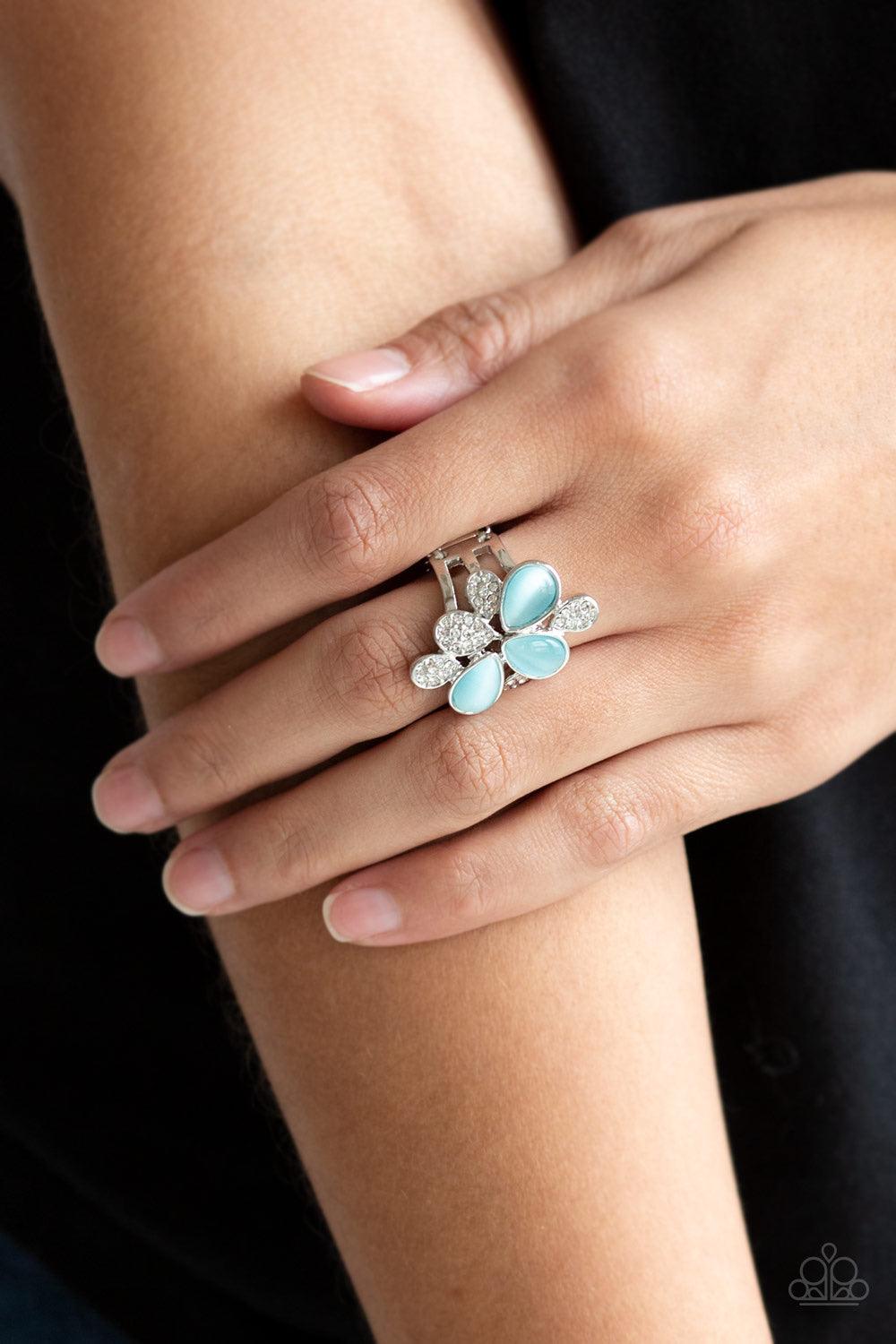 Paparazzi Accessories Diamond Daisies - Blue Featuring tranquil teardrop shapes, glowing blue moonstones and white rhinestone encrusted petals coalesce into an enchanting band for a seasonal look. Features a stretchy band for a flexible fit. Sold as one i