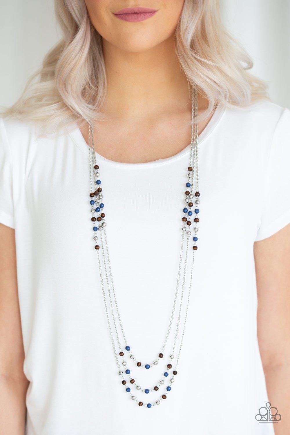 Paparazzi Accessories Seasonal Sensation - Blue Dainty silver, blue, and wooden beads trickle along three shimmery silver chains, creating colorful layers across the chest. Features an adjustable clasp closure. Sold as one individual necklace. Includes on