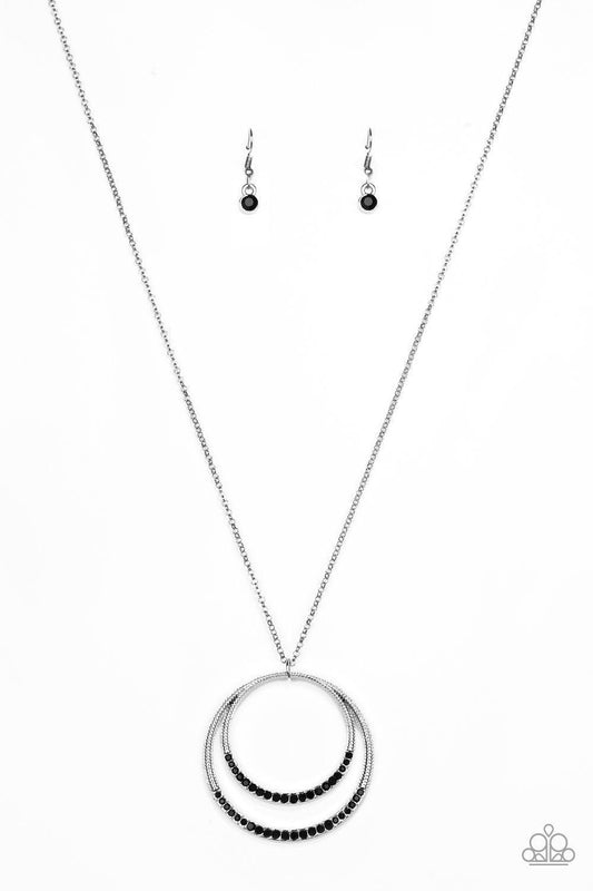 Paparazzi Accessories Front and EPICENTER - Black A daring circular pendant swings from the bottom of an elongated silver chain for a refined look. The bottoms of the ornate silver pendant are encrusted in black rhinestones for a glamorous finish. Feature