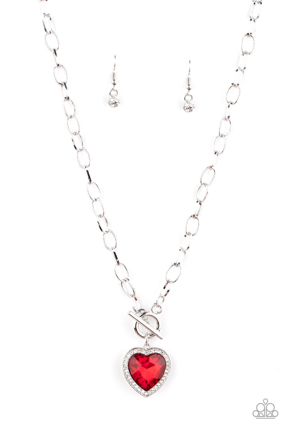 Paparazzi Accessories Check Your Heart Rate - Red Bordered in glassy white rhinestones, a heart-shaped red gem is pressed into a shiny silver pendant at the bottom of a bold silver chain below the collar for a flirtatious finish. Features a toggle closure