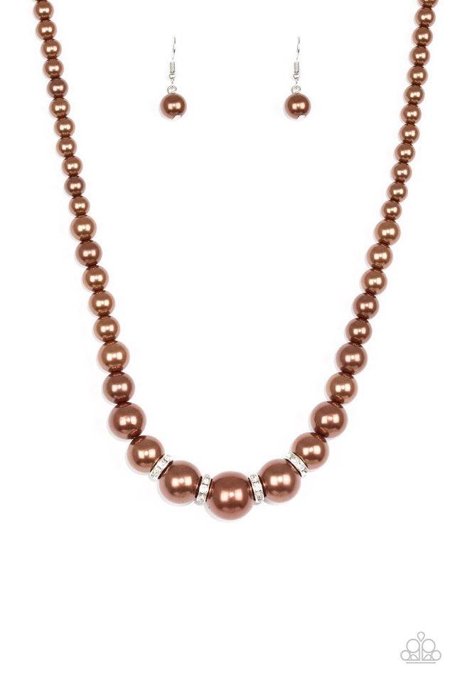 Paparazzi Accessories Party Pearls - Brown Gradually increasing in size, luminescent brown pearls trickle below the collar for a classic look. Encrusted in dazzling white rhinestones, glittery rings are sprinkled between the pearls for a timeless finish.
