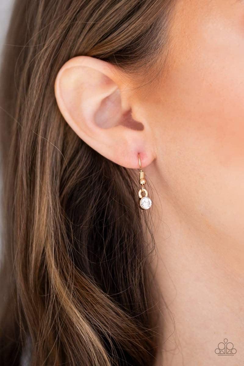 Paparazzi Accessories Gemstone Grandeur - Gold Featuring a raw cut and metallic backing, a golden gem swings from the bottom of an elongated gold popcorn chain. Dotted with a dainty white rhinestone, the faceted gem catches and refracts the light for a bl