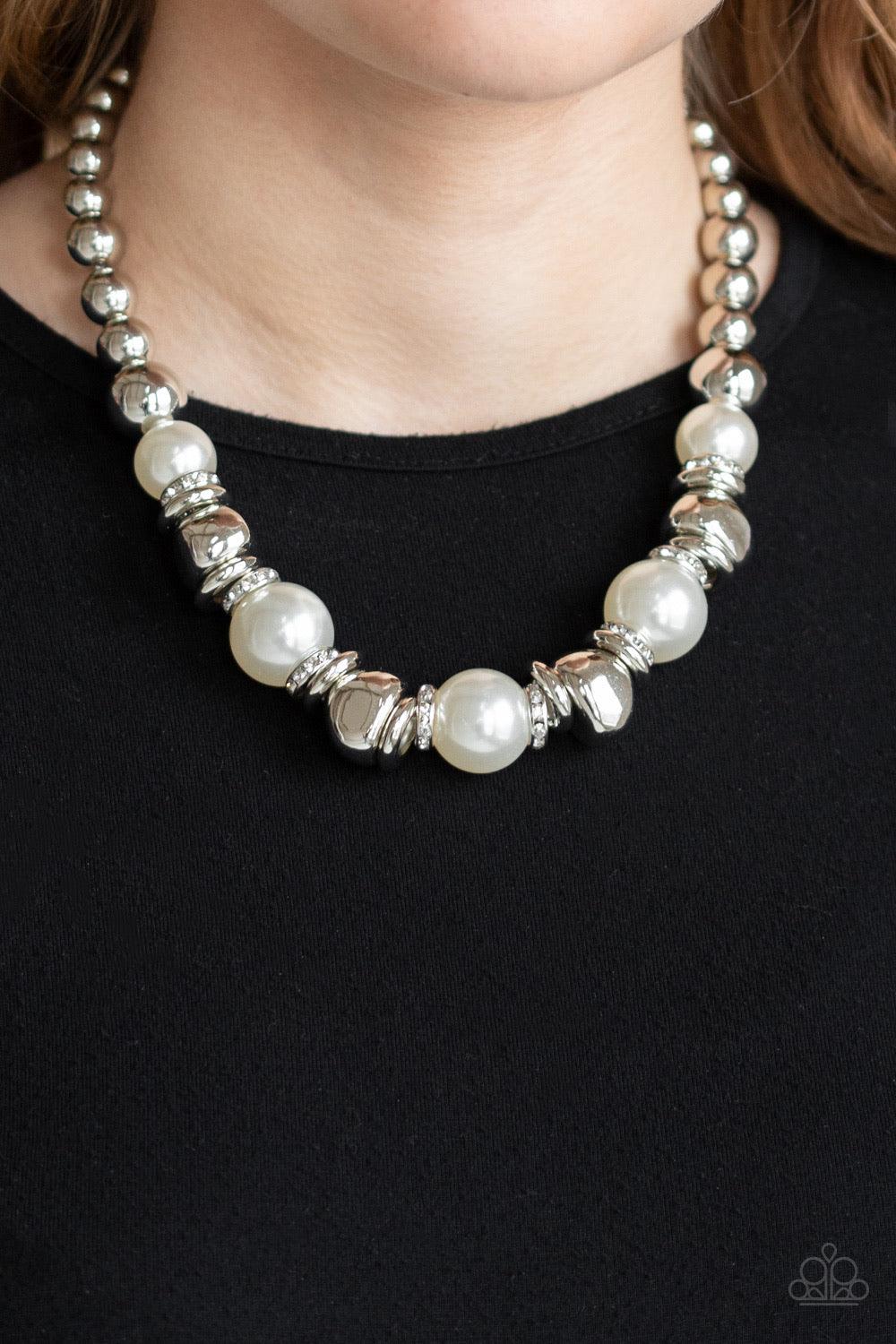 Paparazzi Accessories Hollywood HAUTE Spot - White A collection of oversized white pearls, silver rings, and asymmetrical silver beads are threaded along an invisible wire below the collar. White rhinestone encrusted rings are sprinkled between the refine