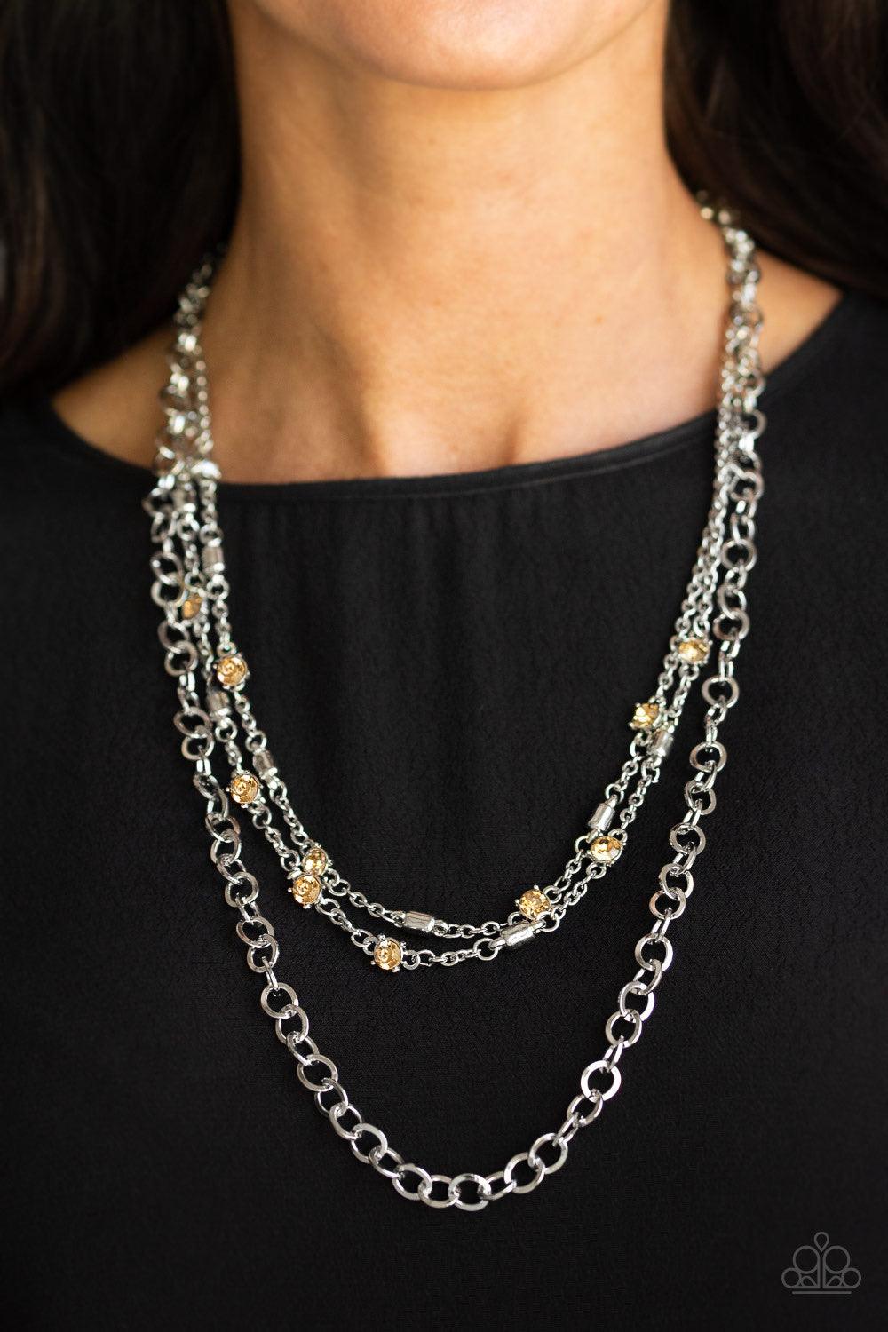 Paparazzi Accessories Metro Mixer - Brown Dotted with golden topaz rhinestones and glistening silver accents, a collision of mismatched silver chains layer down the chest for a refined flair. Features an adjustable clasp closure. Jewelry