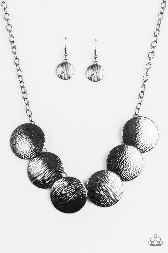 Paparazzi Accessories Glued To The SPOTLIGHT - Black Embossed in shimmery linear patterns, round gunmetal frames link below the collar for a bold industrial look. Features an adjustable clasp closure. Sold as one individual necklace. Includes one pair of