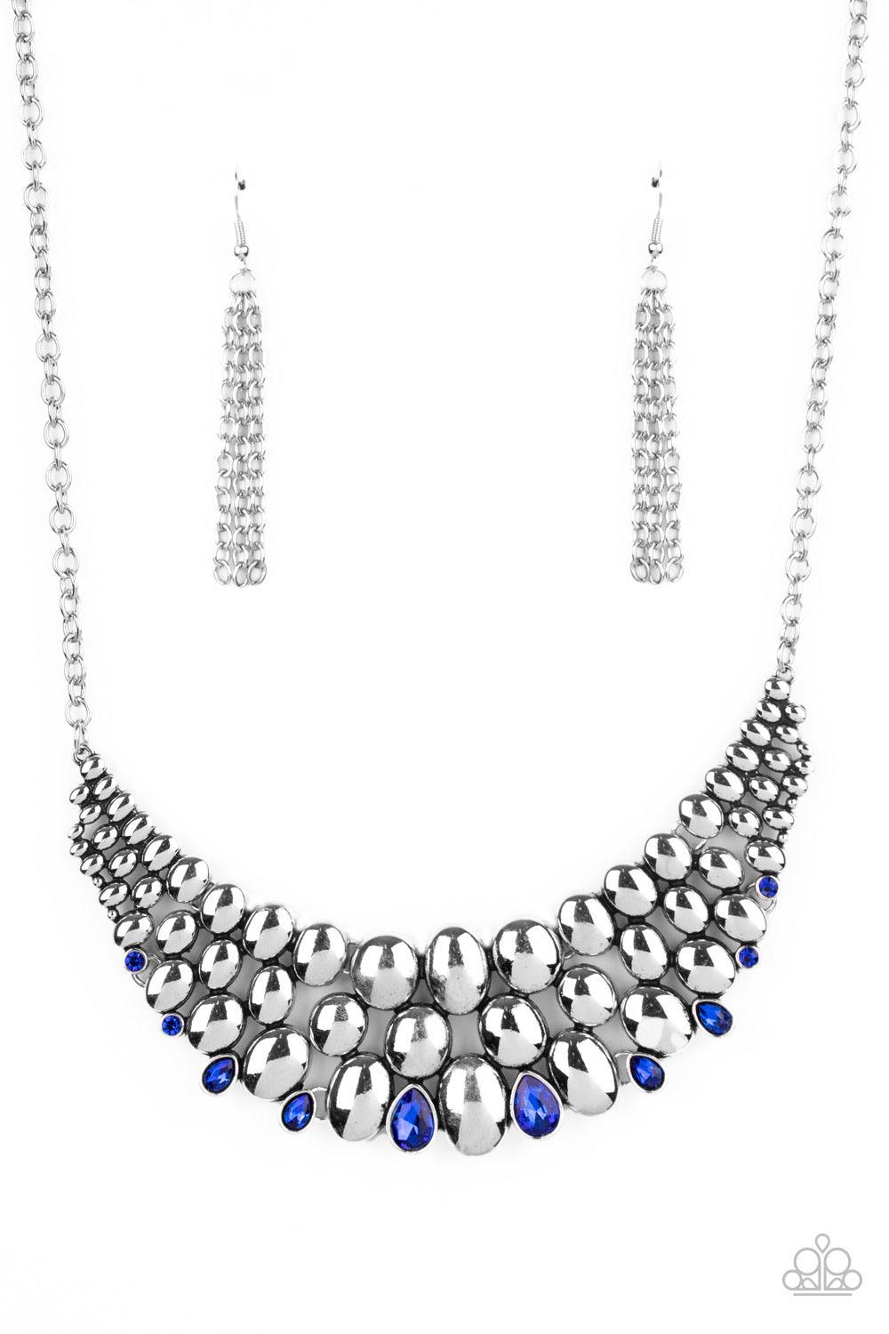 Paparazzi Accessories Powerhouse Party - Blue Gradually increasing in size at the center, a shiny collection of antiqued silver ovals join into bubbly plates that interlock below the collar. Dainty round and teardrop French Blue rhinestones dot the bottom