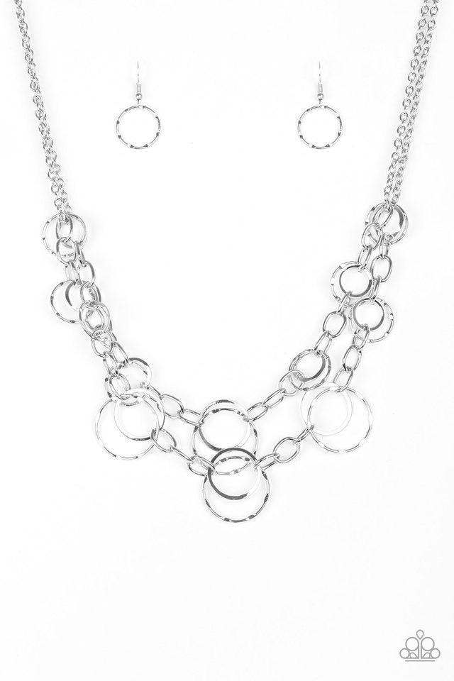 Paparazzi Accessories Urban Center ~Silver Mismatched silver hoops and rings link into two shimmery rows below the collar for a bold industrial look. Features an adjustable clasp closure. Sold as one individual necklace. Includes one pair of matching earr