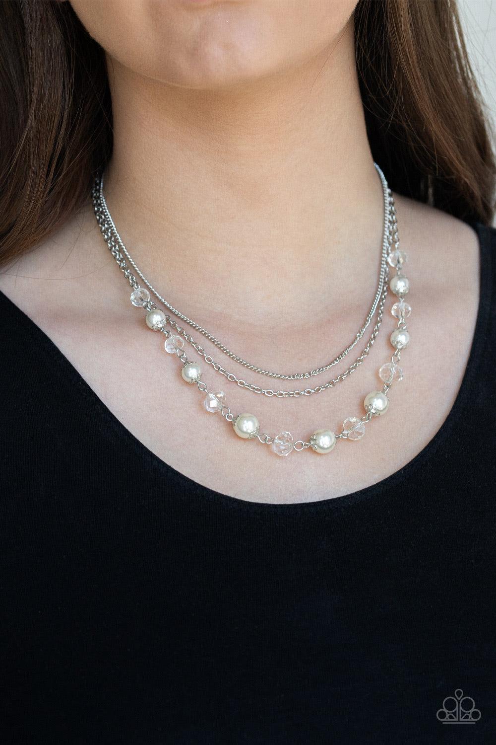 Paparazzi Accessories Tour De Demure - White Infused with two layers of dainty silver chains, pearly white and sparkling crystal-like beads link below the collar for a demure look. Features an adjustable clasp closure. Jewelry
