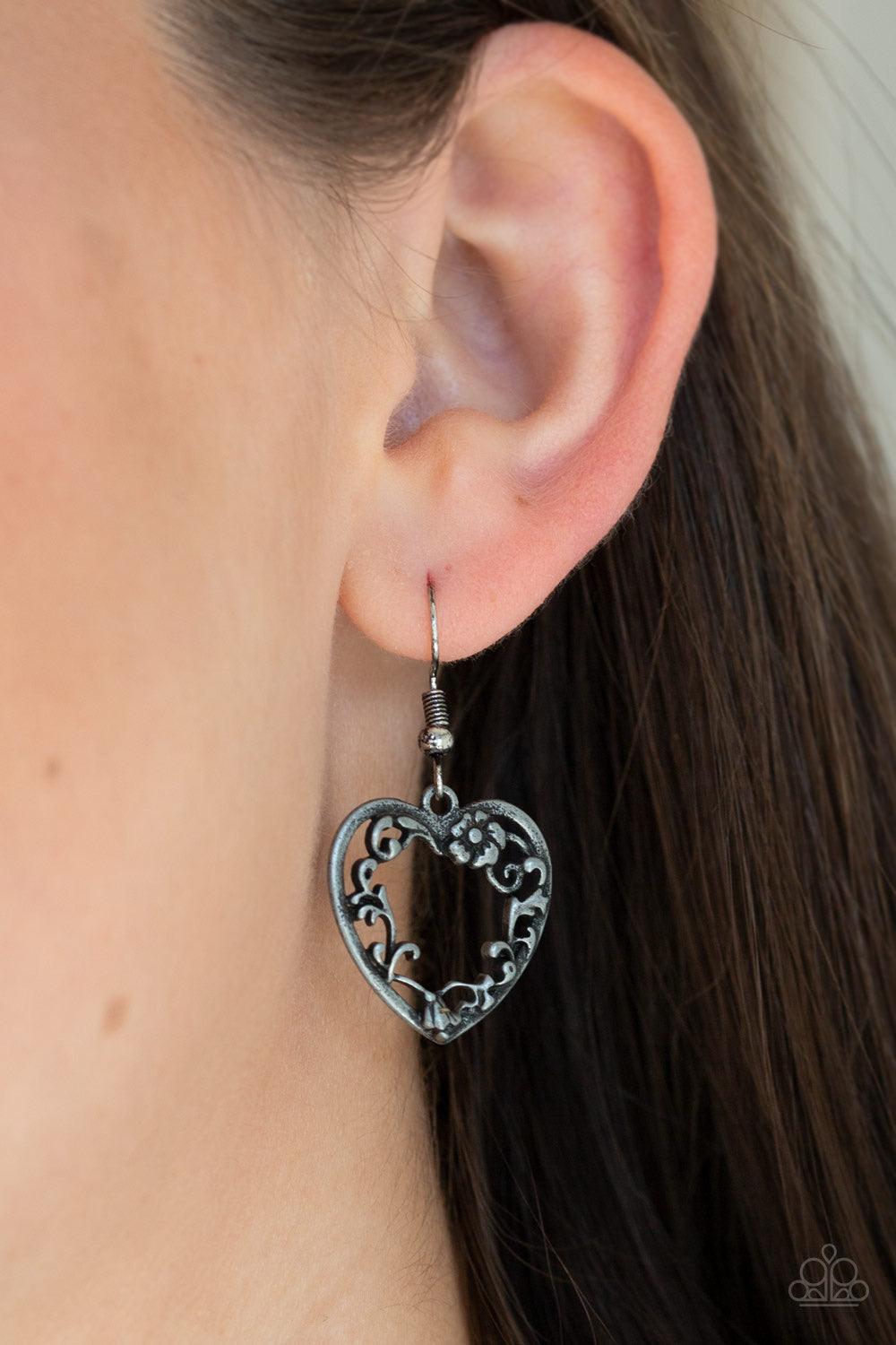 Paparazzi Accessories Garden Lovers - Silver Swirling with ornate floral filigree details, a pair of tin finished silver heart frames link at the bottom of a lengthened silver chain for a vintage inspired look. Features an adjustable clasp closure. Sold a