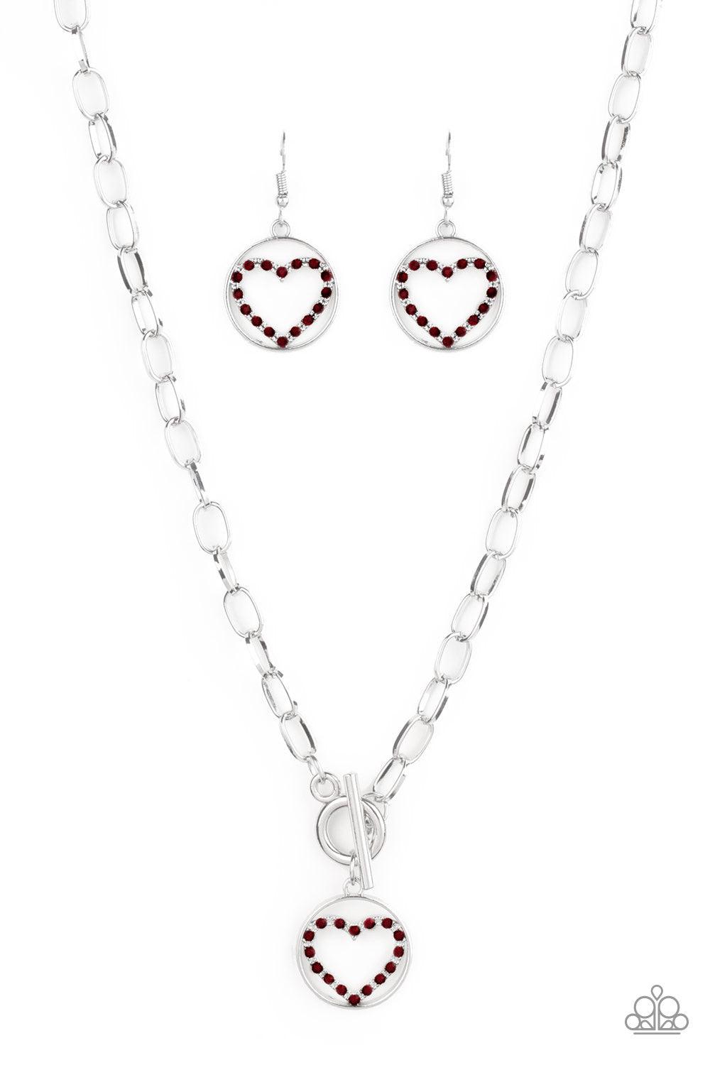 Paparazzi Accessories With My Whole Heart ~Red A red rhinestone encrusted silver heart is nestled inside a shiny silver hoop, creating a charming pendant at the bottom of an exaggerated silver chain. Features a toggle closure.