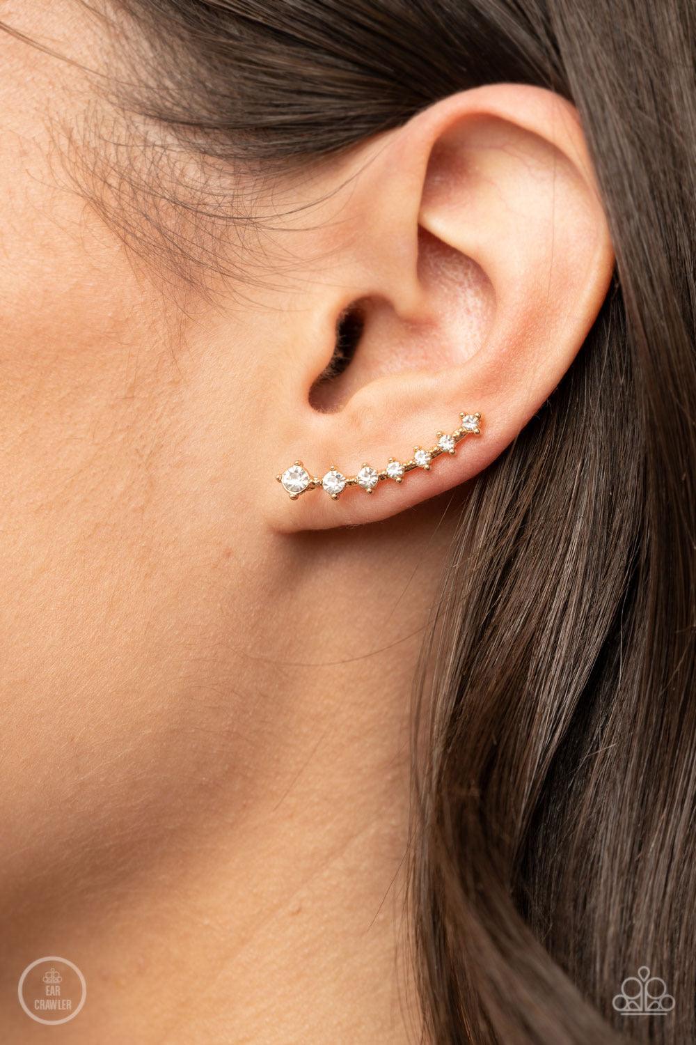 Paparazzi Accessories New Age Nebula - Gold Gradually decreasing in size, a dainty row of glittery white rhinestones curve up the ear for a stellar chic look. Sold as one pair of ear crawlers. Jewelry