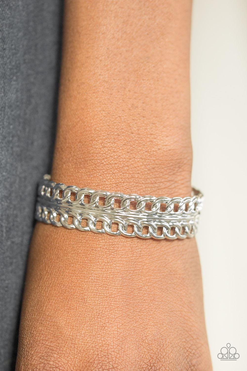 Paparazzi Accessories Progressive Movement - Silver Glistening rows of silver chain link stack across the wrist, coalescing into a bold industrial cuff. Jewelry