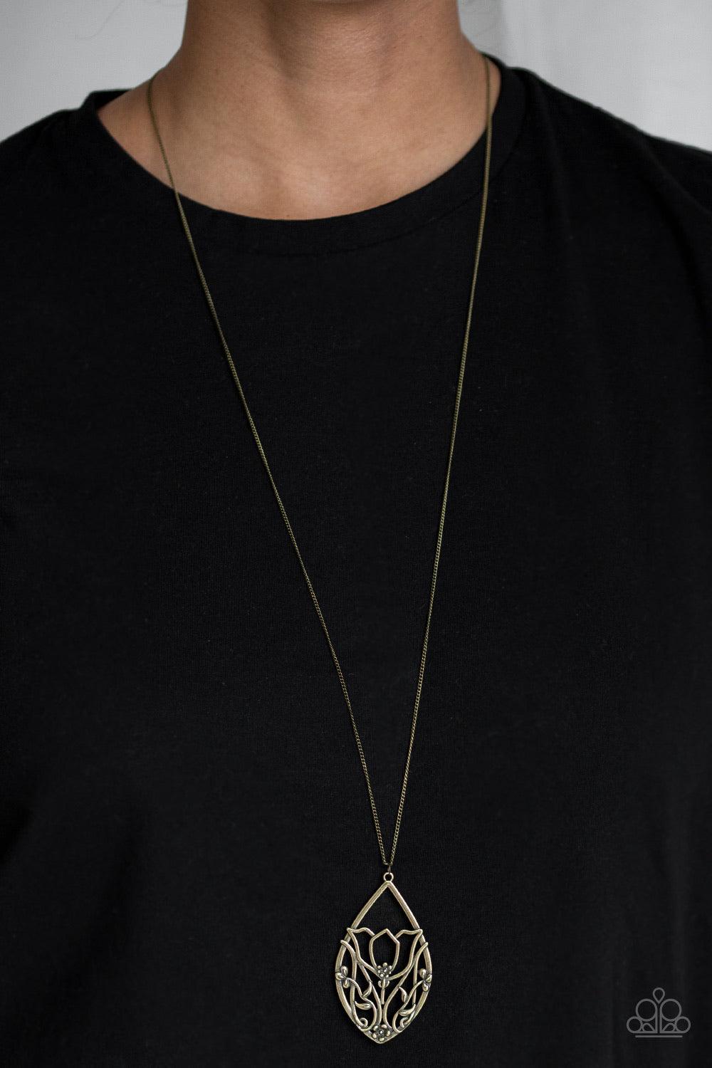 Paparazzi Accessories Eden Enchantment - Brass Dotted with dainty flower accents, glistening brass filigree blooms across a teardrop frame, coalescing into a beautiful floral pendant. Features an adjustable clasp closure. Jewelry