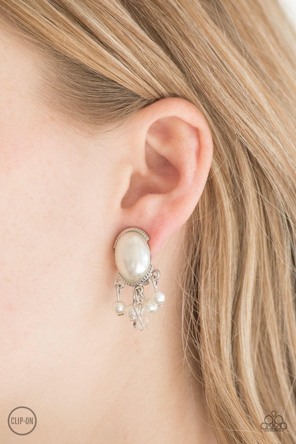 Paparazzi Accessories Classy Casablanca - White *Clip-On Pressed into a sleek silver frame, a pearly white bead gives way to a pearl and crystal-like fringe for a timeless fashion. Earring attaches to standard clip-on fitting. Sold as one pair of clip-on
