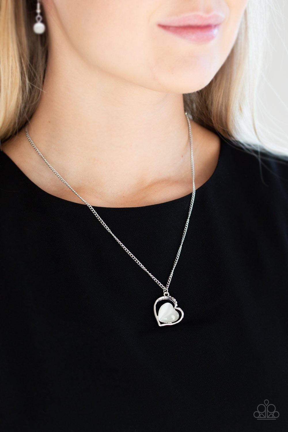 Paparazzi Accessories Love of My Life - White Chiseled into a tranquil heart, a white moonstone is pressed into the center of an airy silver heart frame radiating with sections of glittery white rhinestones for a romantic finish. Features an adjustable cl